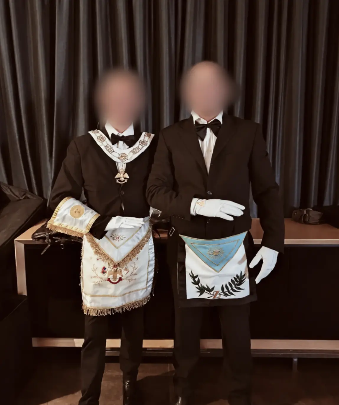 Deux personnes aux visages floutés, portant des tabliers différents et une main devant le corps.